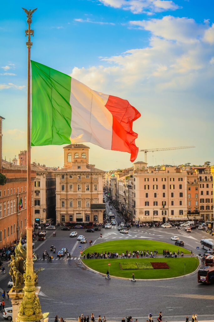 Aerial view of Piazza Venezia in Rome with the Italian flag prominently displayed.